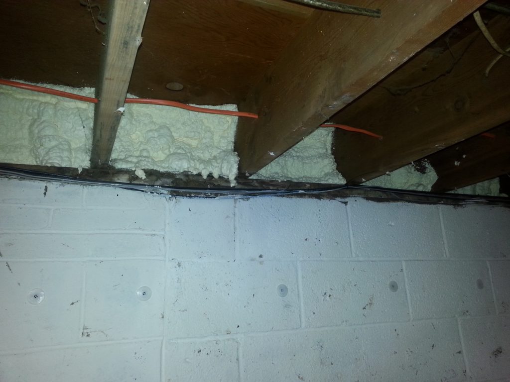 Spray Foam Insulation Services 5 Basement rim joist bays filled with closed-cell spray foam above a block foundation wall
