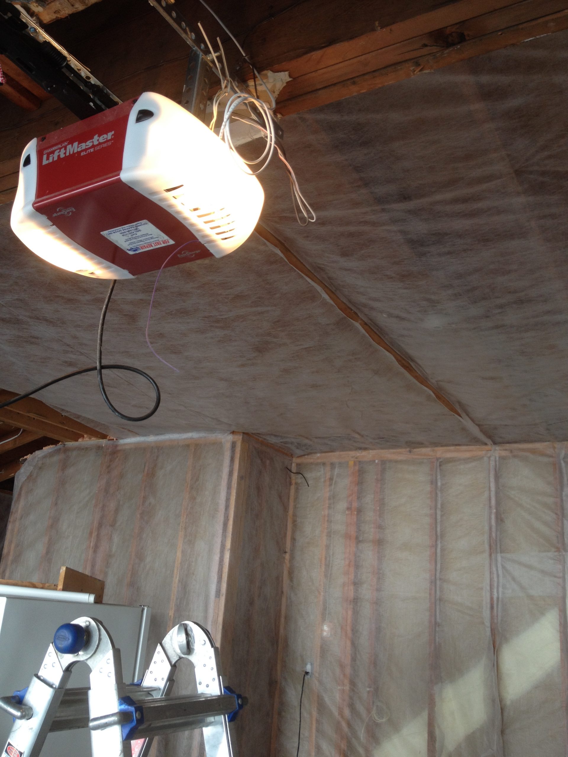 Spray foam insulation on ceiling rafters before drywall installation