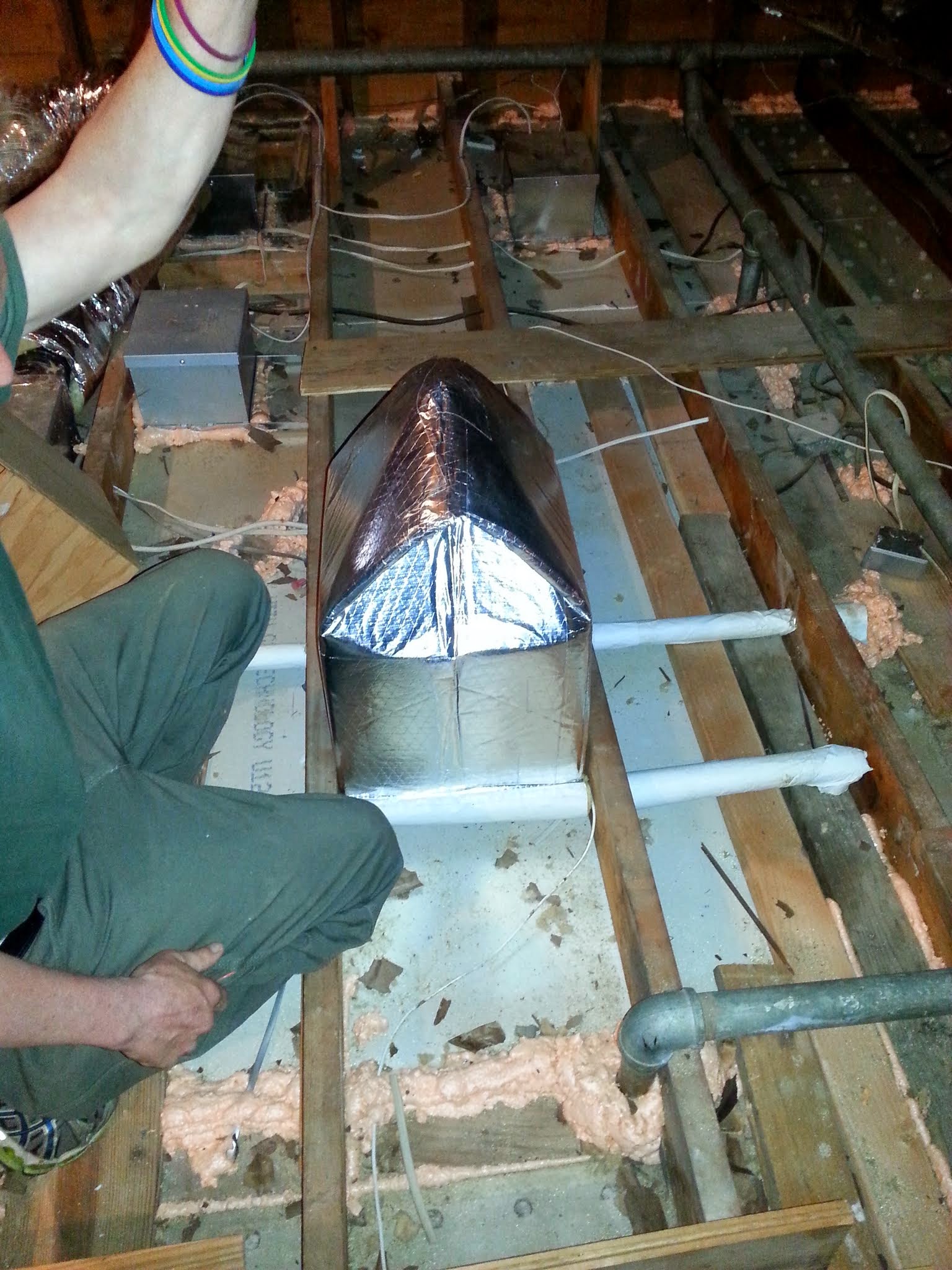 Metro NY Insulation technician sealing attic bypasses with spray foam in New Jersey