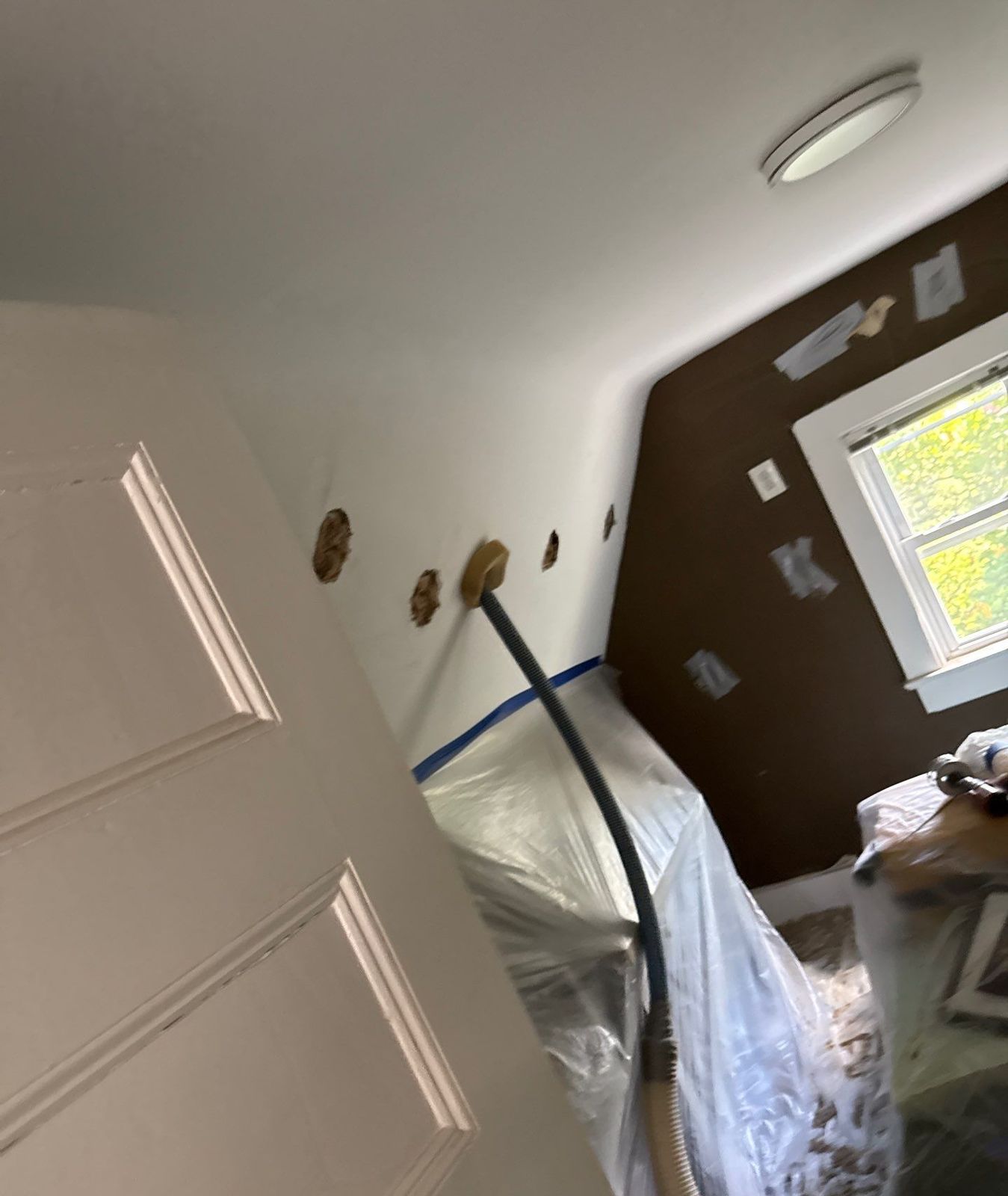 Exterior Dense Pack Cellulose Insulation Installation in White Plains, NY 7 Dense pack cellulose insulation hose filling a finished attic sloped ceiling cavity in a White Plains NY home