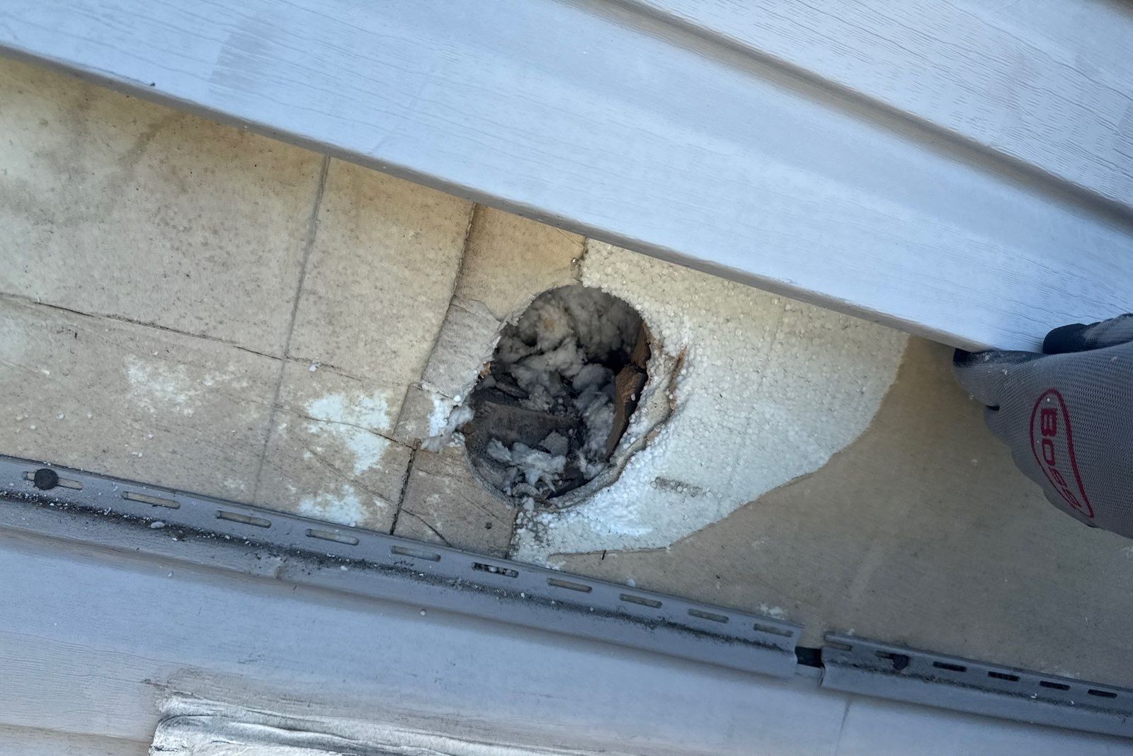 Exterior Dense Pack Cellulose Insulation Installation in White Plains, NY 4 Access hole in exterior sheathing revealing an under-insulated wall cavity with only scraps of old insulation, White Plains NY