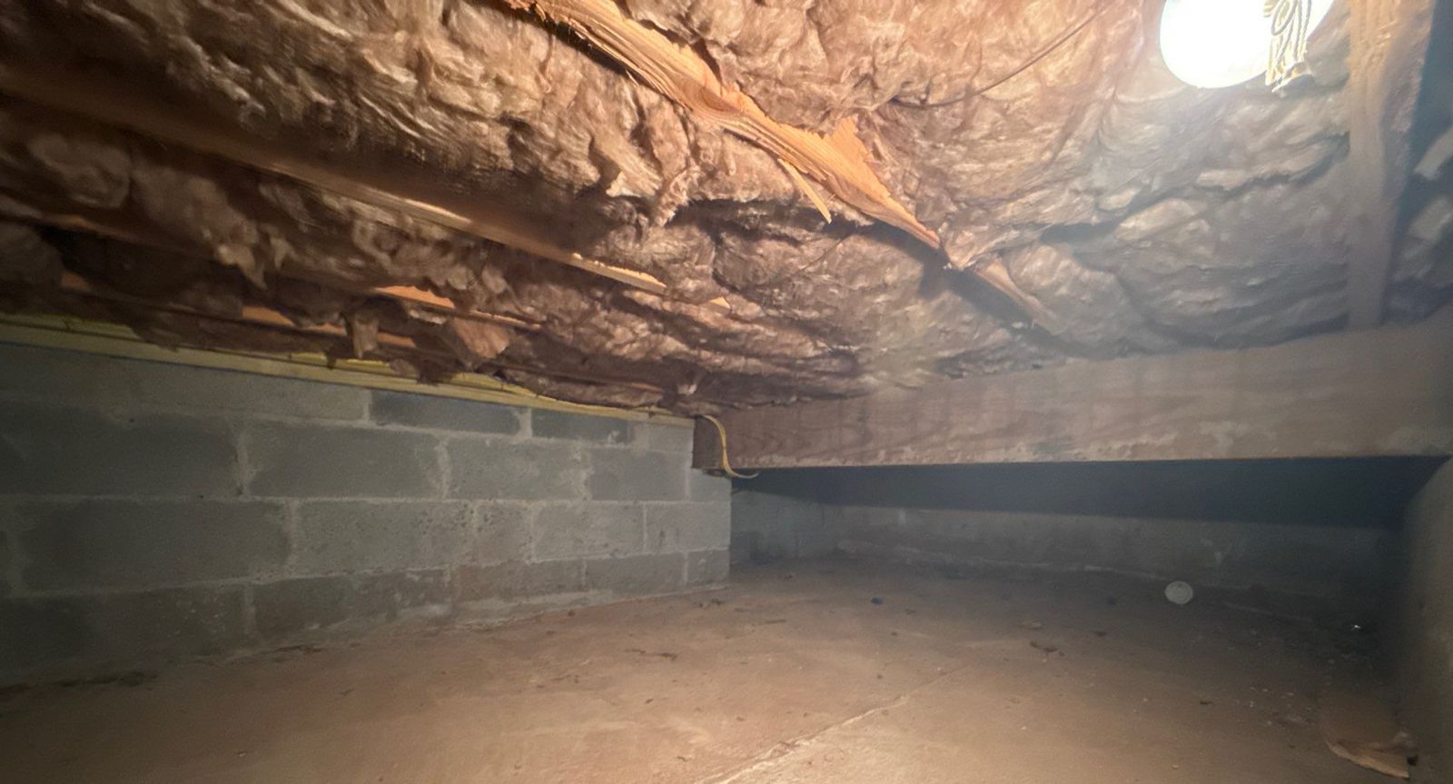 Spray Foam Attic and Crawl Space Insulation in Teaneck, NJ: Project Case Study 5 Crawl space in Teaneck NJ before: sagging fiberglass between joists and open block walls